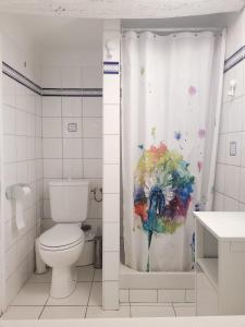 La salle de bains est pourvue de toilettes et d'un rideau de douche. dans l'établissement Cigaloun, à Moissac-Bellevue