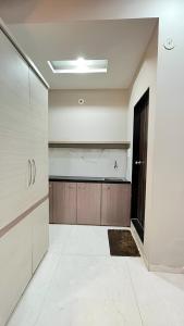 uma grande cozinha com paredes brancas e armários de madeira em Hotel Evanka em Indore