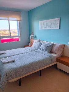 a bedroom with a large bed with blue walls at Apartamento Moderno en Guardamar in Guardamar del Segura