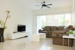 uma sala de estar com um sofá e uma televisão em Luxury Coral Dream em Playa del Carmen