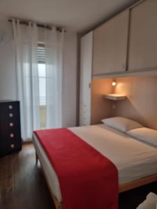 une chambre avec un grand lit recouvert d'une couverture rouge dans l'établissement Home Sweet Home, à Alghero