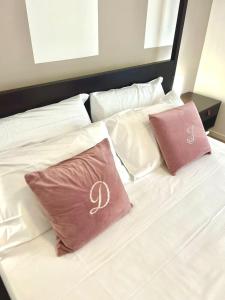 a white bed with two pink pillows on it at Fiera Maison in Verona