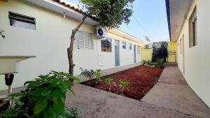 a white building with a garden in front of it at Flat 01 in Jaguariaíva