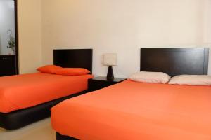 duas camas sentadas uma ao lado da outra num quarto em Luxury Coral Dream em Playa del Carmen