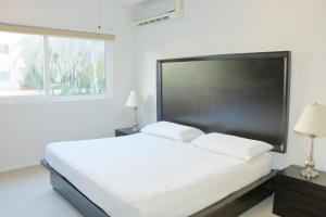 une chambre blanche avec un grand lit et une fenêtre dans l'établissement Luxury Coral Dream, à Playa del Carmen 28 autres photos