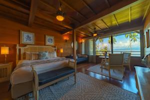 a bedroom with a bed and a view of the ocean at Playa Cativo Lodge in Esquinas