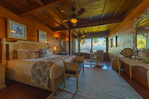 a bedroom with a large bed and a dining room at Playa Cativo Lodge in Esquinas