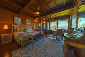 EsquinasにあるPlaya Cativo Lodgeのベッドルーム1室(ベッド1台付)、リビングルームが備わります。