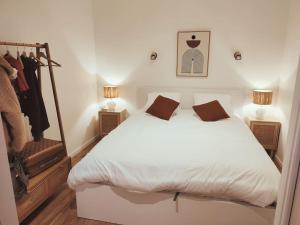een slaapkamer met een groot wit bed en 2 lampen bij Au rue du gaz YourHostHelper in Rodez