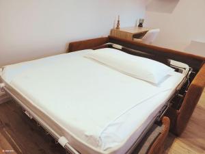 een bed in een ziekenhuiskamer met witte lakens bij Au rue du gaz YourHostHelper in Rodez