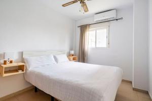a bedroom with a white bed and a window at Centric and spacious flat with free car park in Seville