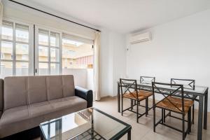a living room with a couch and a table and chairs at Centric and spacious flat with free car park in Seville