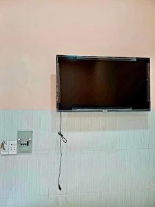 einen Flachbild-TV, der an einer Wand hängt in der Unterkunft NGUYỆT MINH HOTEL in Ấp Phú Lợi