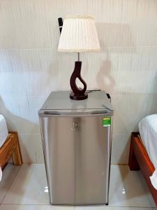 una lámpara en la parte superior de un cubo de basura con una mesa en NGUYỆT MINH HOTEL en Ấp Phú Lợi