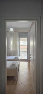 1 Schlafzimmer mit 2 Betten und einer Tür, die zu einem Zimmer führt in der Unterkunft TAM 2BDR Centre Apartment With Veranda in Tirana