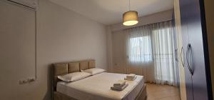 ein Schlafzimmer mit einem Bett mit zwei Handtüchern darauf in der Unterkunft TAM 2BDR Centre Apartment With Veranda in Tirana