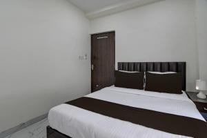 a bedroom with a large bed with a wooden headboard at OYO Park Platinum in Kolkata