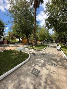 a street with a park with a bench and trees at Hermoso y Confortable Depto in Mendoza