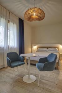 a bedroom with a bed and a table and chairs at Dimora Punta Ala in Punta Ala