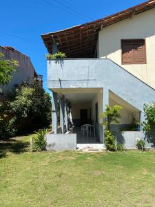 a white house with a table in a yard at Beleza e praticidade no bairro Mirante in Santa Cruz Cabrália