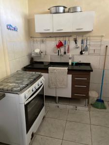 a kitchen with a stove and some utensils at Beleza e praticidade no bairro Mirante in Santa Cruz Cabrália