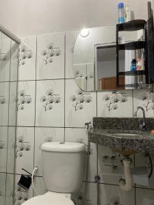 a bathroom with a toilet and a sink at Beleza e praticidade no bairro Mirante in Santa Cruz Cabrália