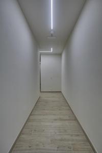 um corredor com paredes brancas e piso de madeira em Dimora Punta Ala em Punta Ala