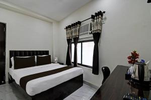 a bedroom with a large bed and a window at OYO Park Platinum in Kolkata