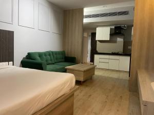 ein Schlafzimmer mit einem Bett und einem Sofa sowie eine Küche in der Unterkunft Upasana First Avenue Studio with pool in Jaipur