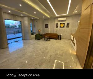 Habitación con vestíbulo con sofá y mesa en Upasana First Avenue Studio with pool en Jaipur