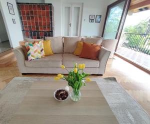 a living room with a couch and a vase with flowers at Dorka Villa in Tihany