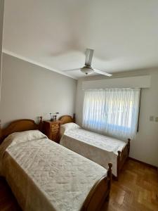 1 dormitorio con 2 camas y ventilador de techo en Hermoso y Confortable Depto en Mendoza