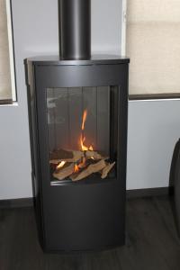 a black fireplace with a fire in it at Huisje Zeertevree in Nieuwvliet