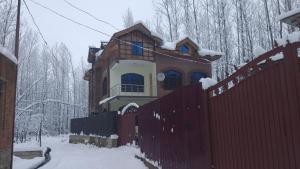 a house with a fence in the snow at Moonlight Homestay Gulmarg in Srinagar