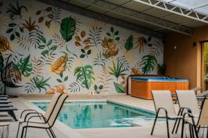 a swimming pool with a mural of butterflies on a wall at Plaza La - Night and Spa in Sremska Mitrovica