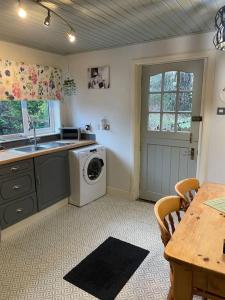 a kitchen with a washing machine and a sink at Station Cottage in Fort William