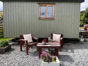 a patio with a table and chairs and a building at Shepherd's Hut Bilsdale in Chop Gate