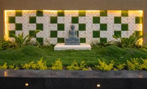 a statue sitting in the middle of a garden at Alaya Heaven in Hills Luxe 2BHK Villa with Pvt Pool, Udaipur in Udaipur