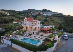 an aerial view of a house with a swimming pool at Spacious villa with private eco-pool and panoramic sea view in Agia Pelagia