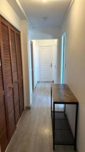 une chambre avec une table et un couloir avec une porte dans l'établissement Joli appartement près de Rouen, à Le Petit-Quevilly