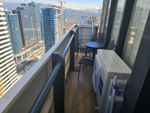 a balcony with a desk and chairs on a building at Orbi City Tower Best Apartment in Batumi in Batumi