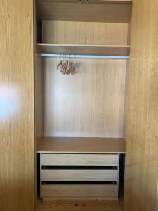 a walk in closet with a wooden cabinet with drawers at mi ático en plaza España in Ribeira