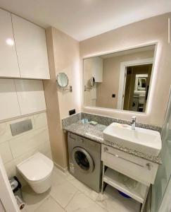 a bathroom with a sink and a washing machine at Orbi City Tower Best Apartment in Batumi in Batumi