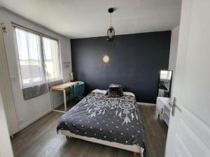 - une chambre avec un lit et un mur noir dans l'établissement Joli appartement près de Rouen, à Le Petit-Quevilly