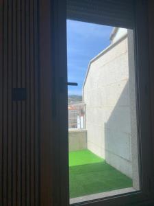 uma janela aberta com vista para um campo verde em mi ático en plaza España em Ribeira
