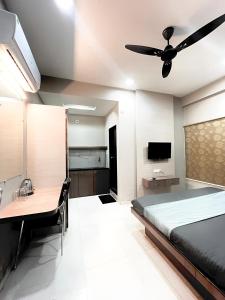 a bedroom with a bed and a desk and a ceiling fan at Hotel Evanka in Indore +6 photos