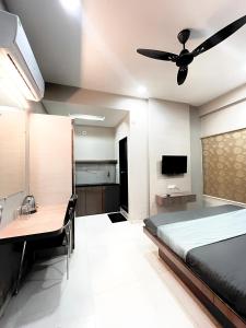 Schlafzimmer mit einem Bett, einem Schreibtisch und einem Deckenventilator in der Unterkunft Hotel Evanka in Indore