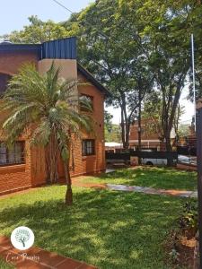 uma palmeira num quintal ao lado de um edifício em Casa Paraíso Urutaú em Puerto Iguazú