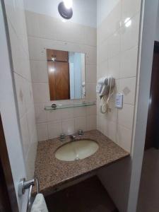 uma casa de banho com um lavatório e um espelho em Casa Paraíso Urutaú em Puerto Iguazú