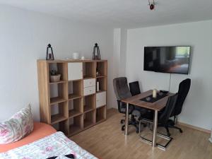 a room with a table and chairs and a television at 2 Raum Zwickau Privat in Zwickau